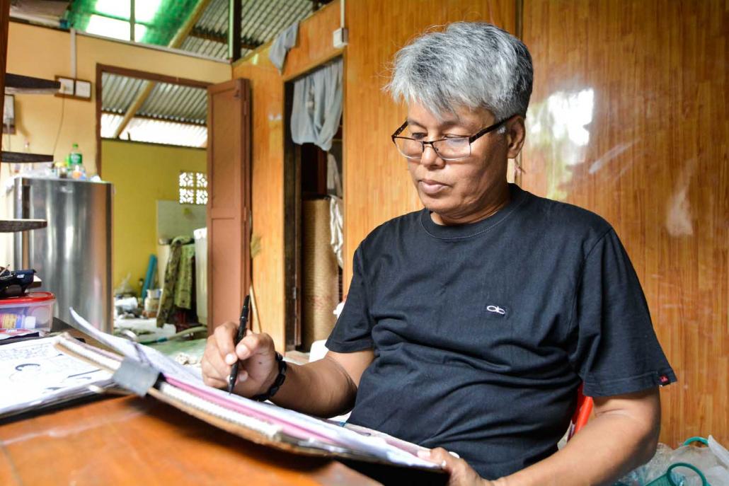 U Myint Tay, better known as the cartoonist U Poe Zar, at work in his Yangon office. (Teza Hlaing | Frontier)