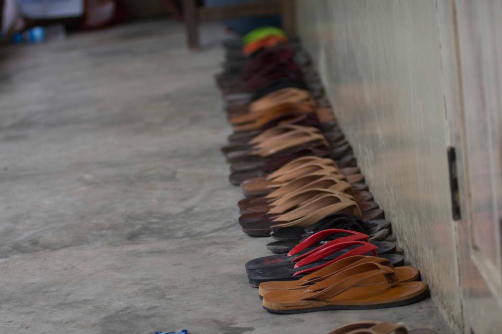 Monks' slippers lined up outside a doorway. (Teza Hlaing / Frontier)