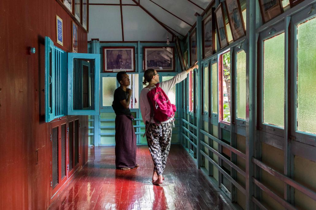 A tourist looks at historic photos in the monastery. (Teza Hlaing / Frontier)