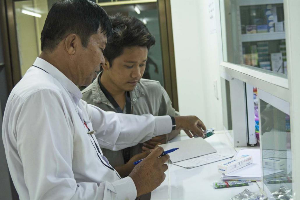 A doctor and patient at an SSBCare Well clinic in outer Yangon. The clinics are run in partnership with a private company, Care Well Medical. (Teza Hlaing | Frontier)