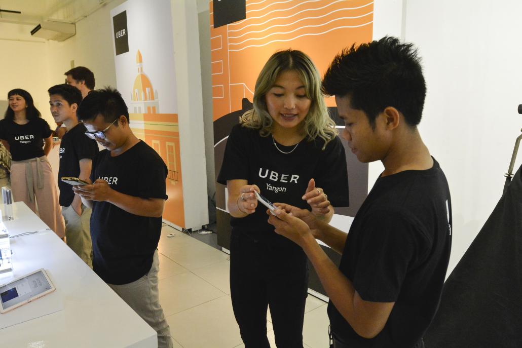 An Uber staffer explains the service at the company's launch in Yangon on May 11. (Teza Hlaing | Frontier)