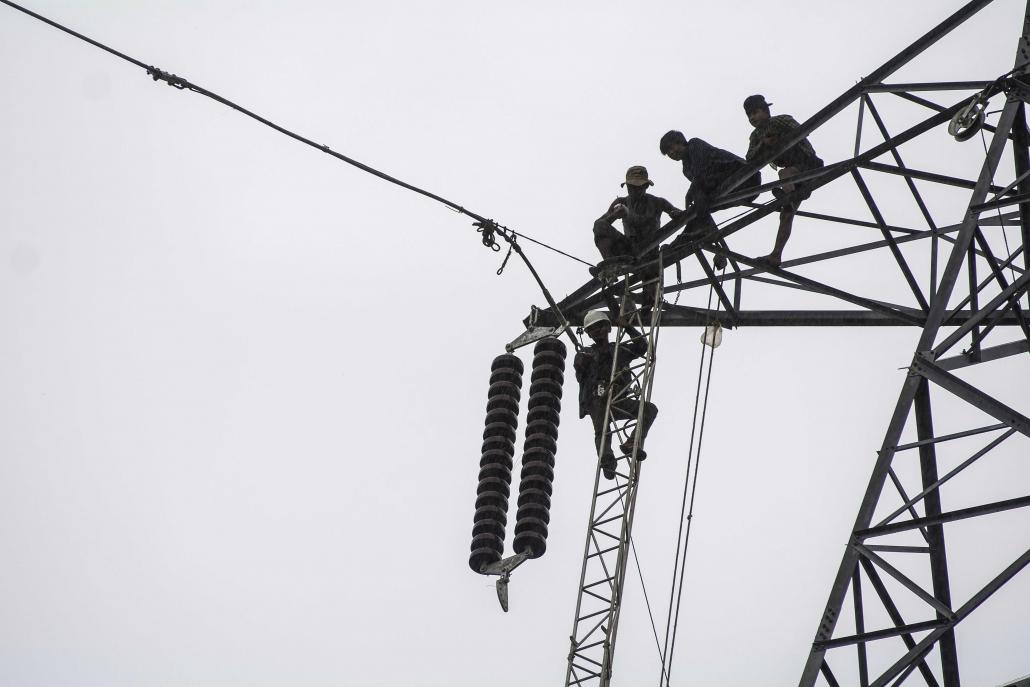 Workers install high-voltage transmission lines in Ann Township, Rakhine State. (Teza Hlaing | Frontier)