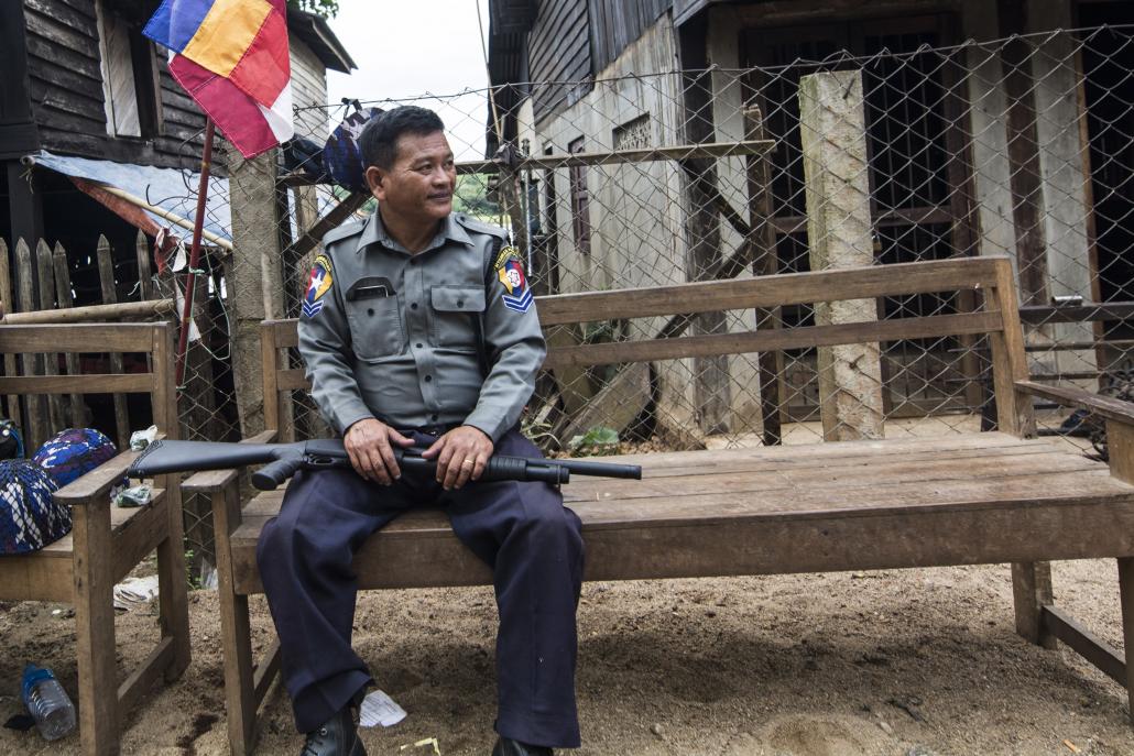 A police officer rests during a patrol of Thuye Thumain village on Friday. (Teza Hlaing / Frontier)