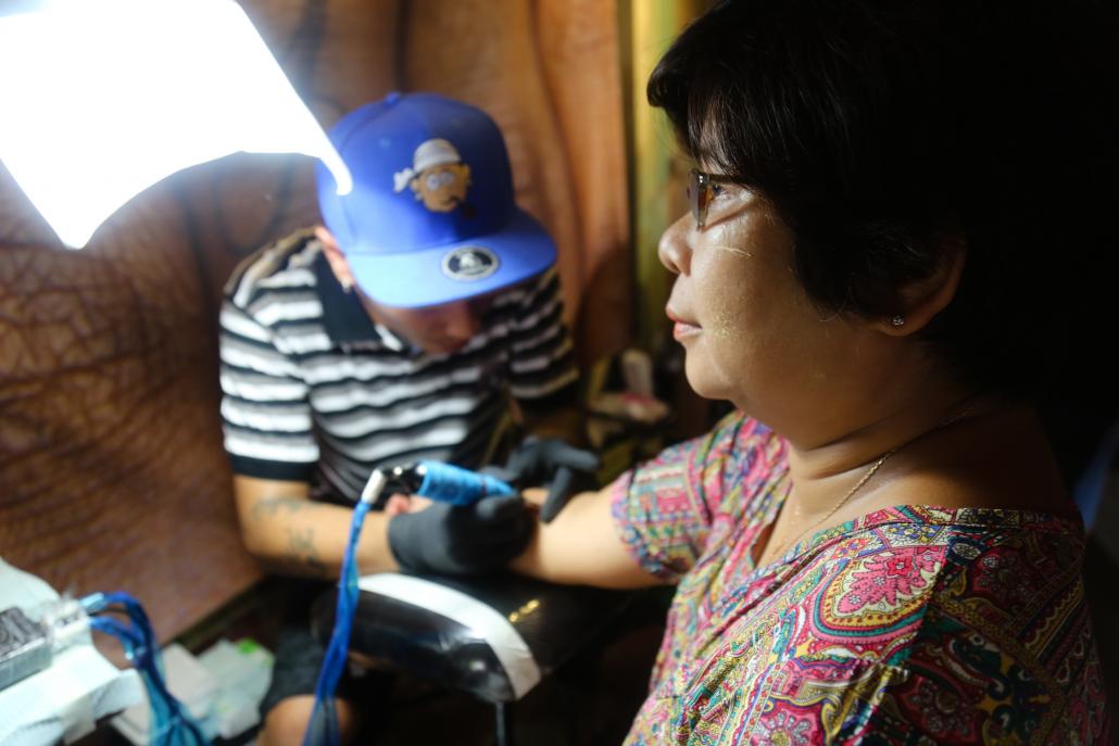 A woman at the Human Rights Tattoo event in Yangon's Pansodan Scene gallery. (Victoria Milko / Frontier)