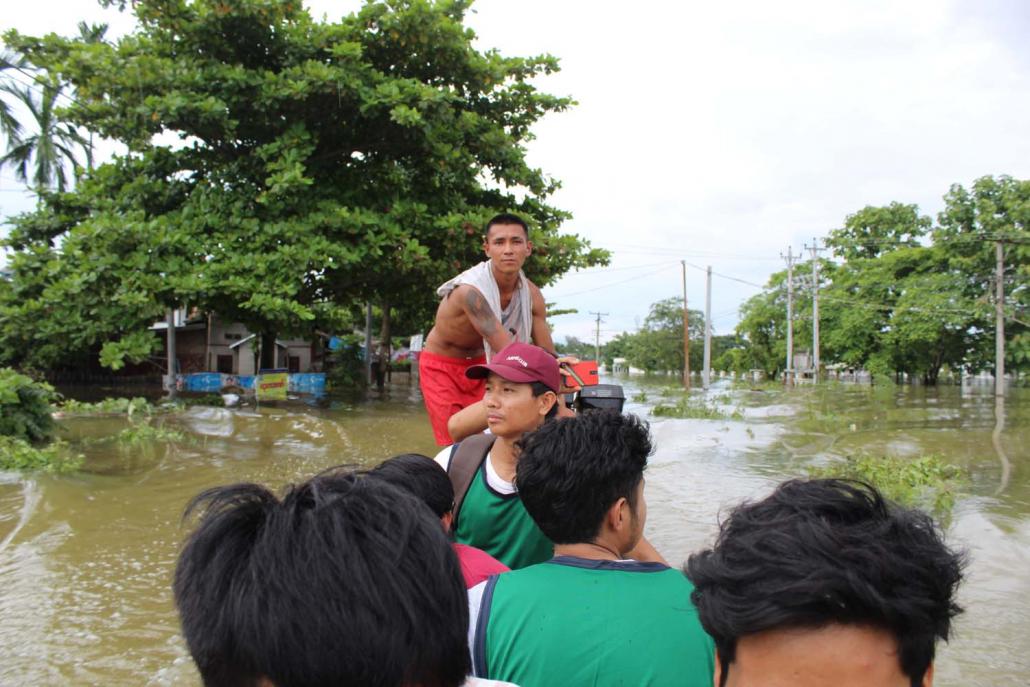 Youth volunteer Wun Zup Aung and others ride a motorboat through a flooded Gyet Poung Chan ward. (Emily Fishbein | Frontier)