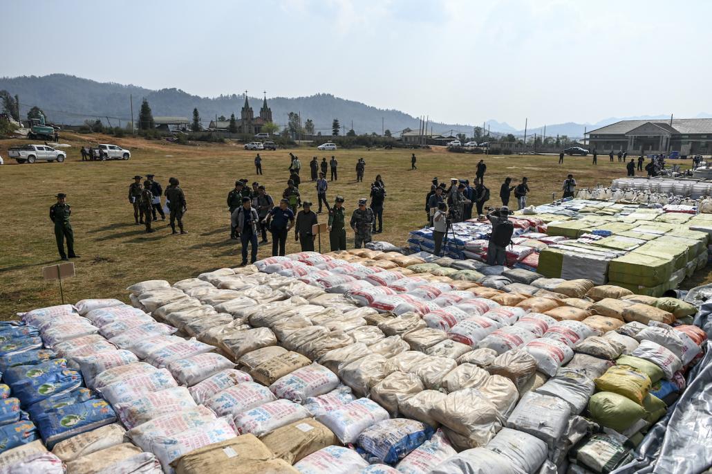 Foreign military attaches and journalists view drugs in a football ground where seized drugs, vehicles, laboratory accessories and precursor chemicals are being displayed in Kutkai Township, Shan State. (AFP)