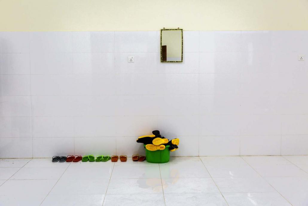 Boots and rubber slippers sit on the floor of a personal protective equipment (PPE) changing room at the South Okkalapa Maternal and Child Hospital in Yangon on March 26. (Hkun Lat | Frontier)