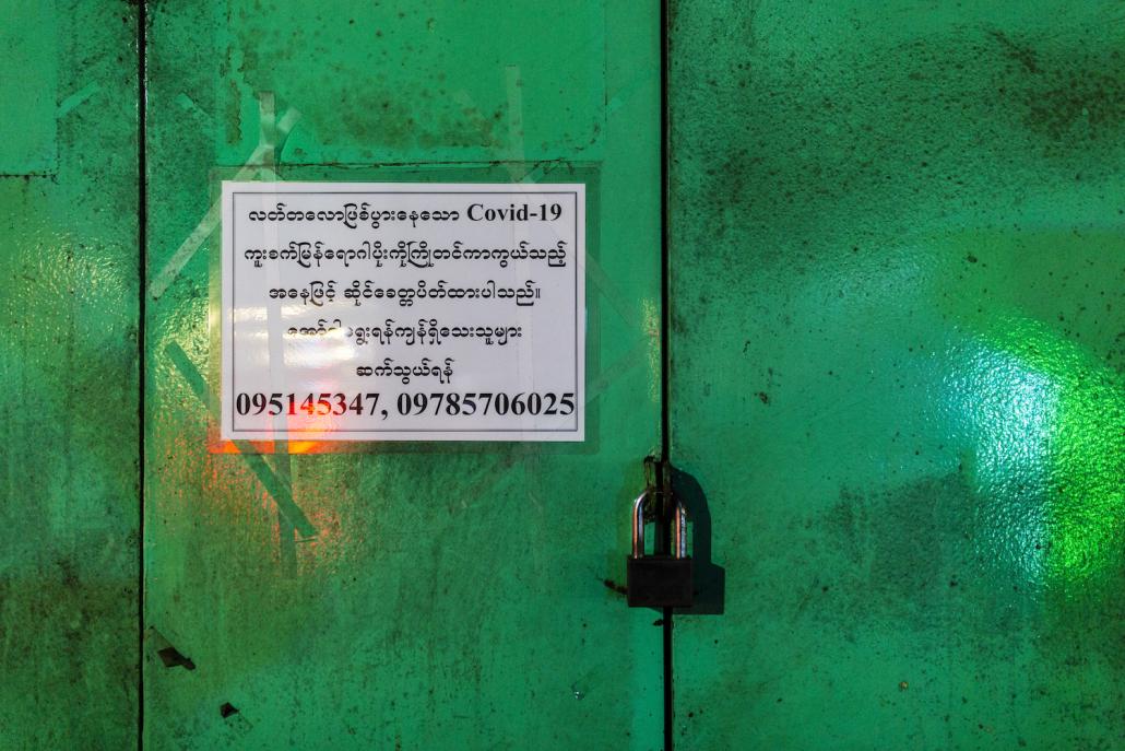 A sign on a shuttered jewellery shop on Mahabandoola Road in downtown Yangon advises customers to call the phone numbers if they want to pick up their orders. (Hkun Lat | Frontier)