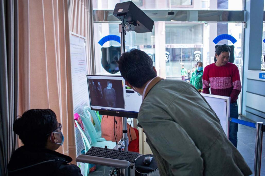 Myanmar health officers operate a thermal scanner to check the temperatures of people entering Myanmar at Muse in northern Shan State on January 31. (AFP)