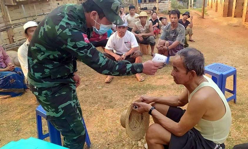 A soldier from the Shan State Army-South, armed wing of the Restoration Council of Shan State, checks a person for fever, one of the symptoms of COVID-19. (Supplied) 