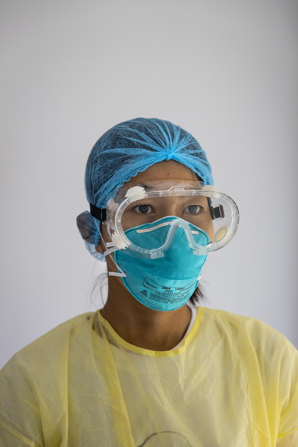 A medical worker in protective gear who has been assigned to stay at a "quarantine hotel" along with people who have returned from abroad. The day of the test was the first time she'd left the hotel in 11 days. (Hkun Lat | Frontier) 