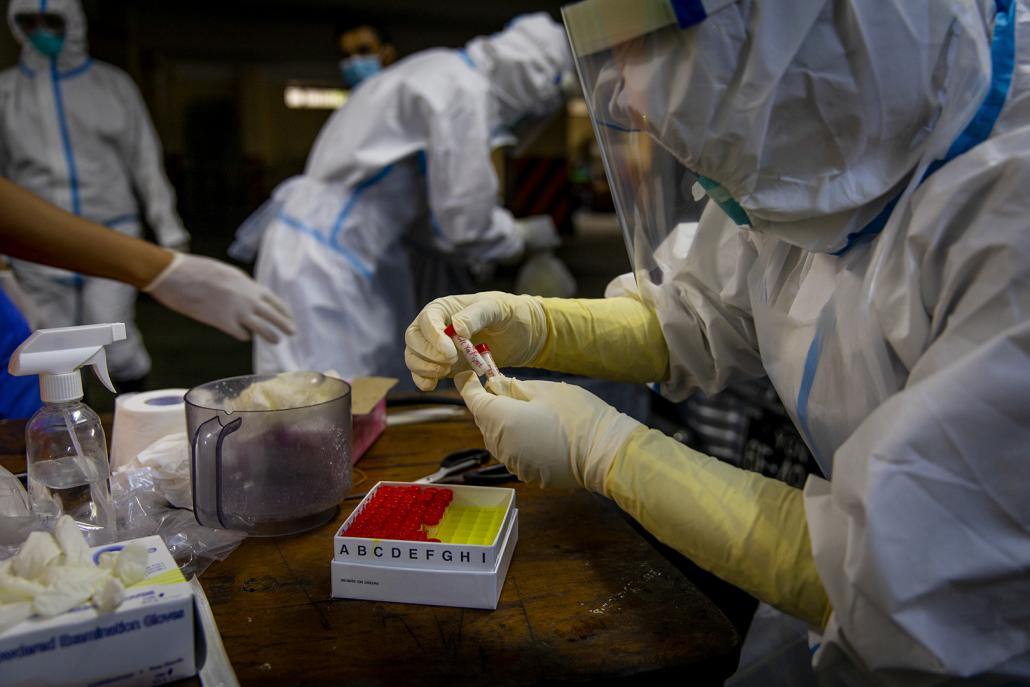 The viral transport medium tubes are placed in a box, wrapped in plastic and then placed in an ice chest to keep the samples at the required temperature. (Hkun Lat | Frontier)