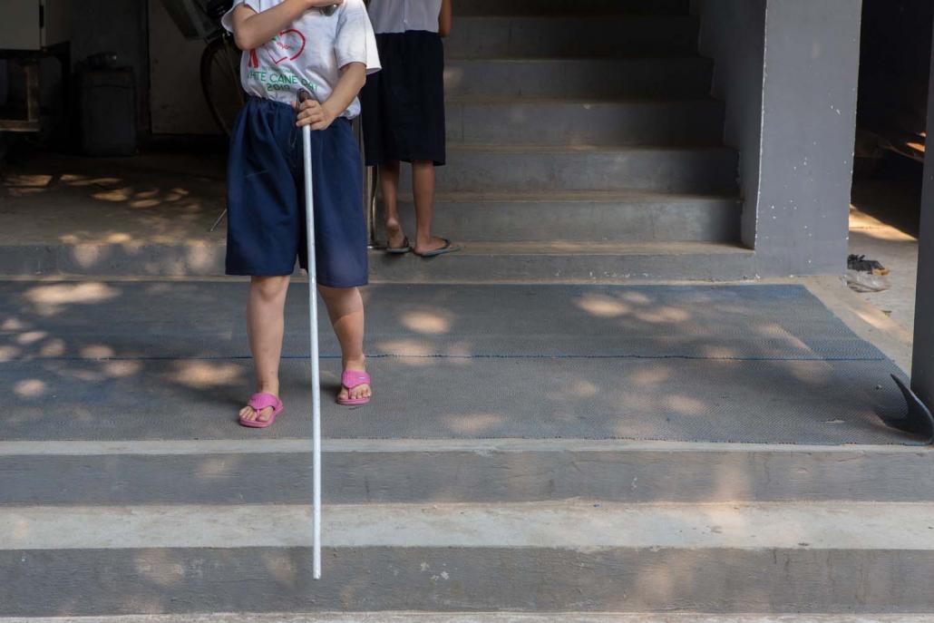 A visually impaired child walks with the aid of a cane at the Myanmar Christian Fellowship of the Blind in Yangon's Insein Township. (Thuya Zaw | Frontier)