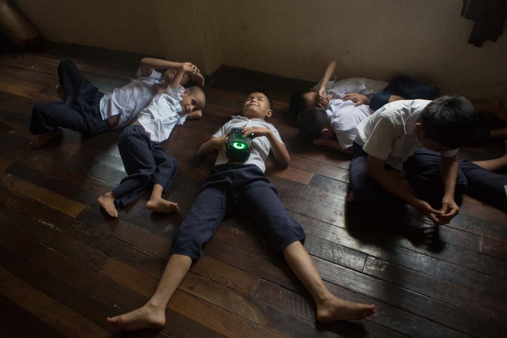 Visually impaired children relax with a radio at the Myanmar Christian Fellowship of the Blind in Yangon's Insein Township. (Thuya Zaw | Frontier)