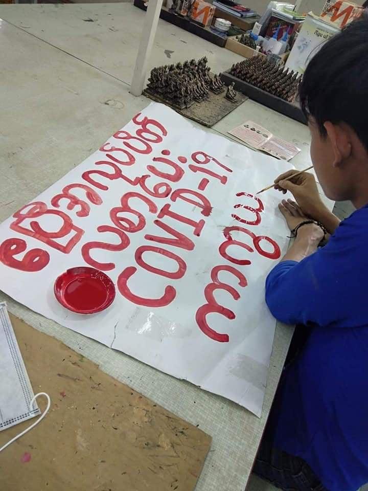 A worker paints a sign calling for factories to be shut in April and workers to receive full pay in order to prevent the spread of the coronavirus. (FGWM | Supplied)