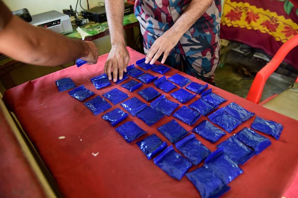 ဘင်္ဂလားဒေရှ့် လုံခြုံရေးတပ်ဖွဲ့ဝင်များက ဖမ်းဆီးရမိထားသည့် စိတ်ကြွဆေးပြားများအား တွေ့ရစဉ်။ ဓာတ်ပုံ-အေအက်ဖ်ပီ