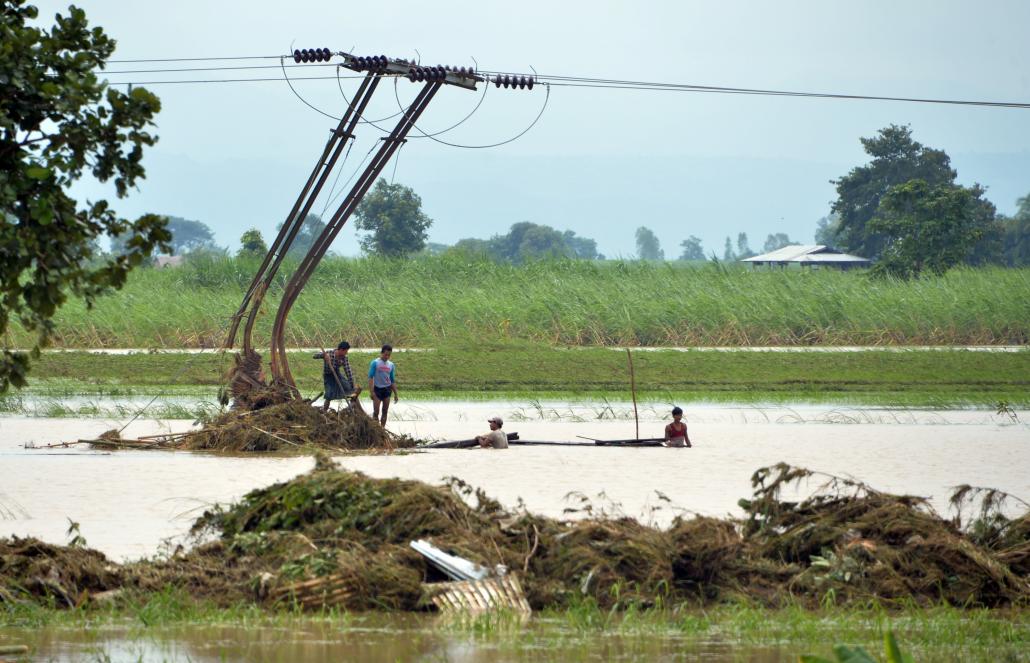 ရေစီးအားကြောင့် ကွေးကောက်သွားသည့် ဓာတ်အားတိုင်တစ်ခုအား တွေ့ရစဉ်။ ဓာတ်ပုံ-အေအက်ဖ်ပီ