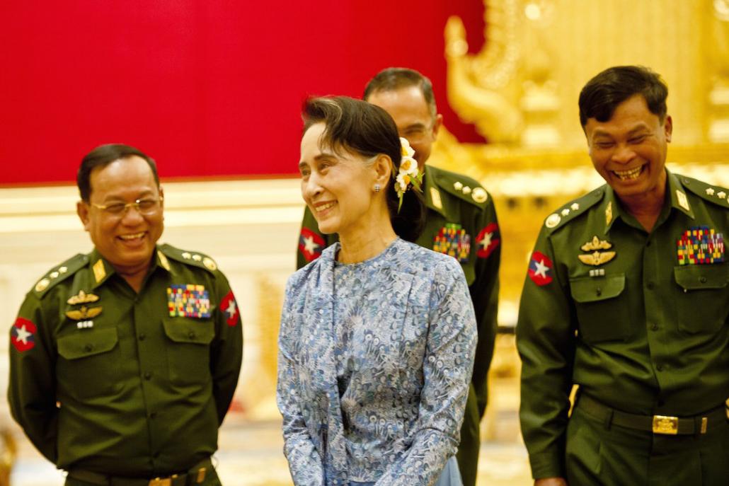 မတ် ၃၀ ရက်နေ့က ကျင်းပသည့် သမ္မတတာဝန်လွှဲပြောင်းပွဲသို့ တက်ရောက်လာသည့် ဒေါ်အောင်ဆန်းစုကြည်အား တပ်မတော်သား ပြည်ထောင်စုဝန်ကြီးသုံးဦနှင့်အတူ တွေ့ရစဉ်။ ဓာတ်ပုံ- အေအက်ဖ်ပီ