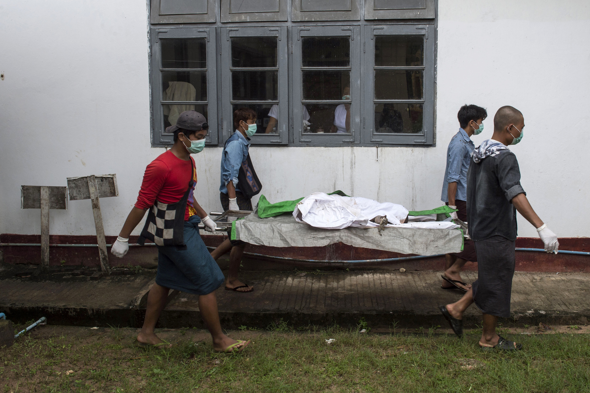 Hospital workers carry the body of three-year-old Nay La Linn, a victim of an exorcism ritual, out of the morgue of Twante Hospital last year. (AFP)