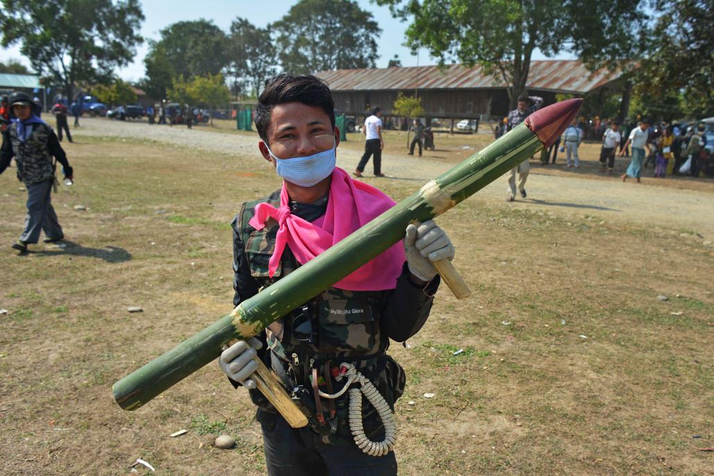 A member of Pat Jasan holds a mock weapon made from bamboo outside the group's headquarters in Waingmaw in February 2016 after returning from a mission to destroy opium fields. (AFP)