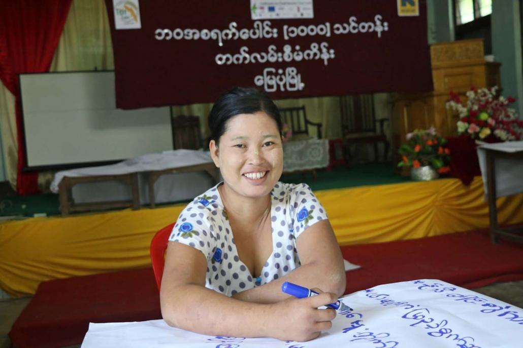 တက်လမ်းမှ လုပ်အားပေးဖြစ်သူ မသင်းဖြူဖြူဝင်းက မိခင်နို့တိုက်ကျွေးမှုနှင့် ပတ်သက်ပြီး တွေ့ကြုံရသည့် အတားအဆီးများကို ရေးသားနေစဉ်။ ဓာတ်ပုံ-တက်လမ်း