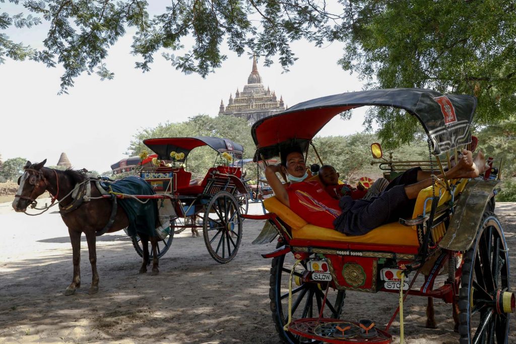 An under-employed horsedrawn carriage driver lounges at the Thatbyinnyu temple on June 23. (Nyein Su Wai Kyaw Soe | Frontier)