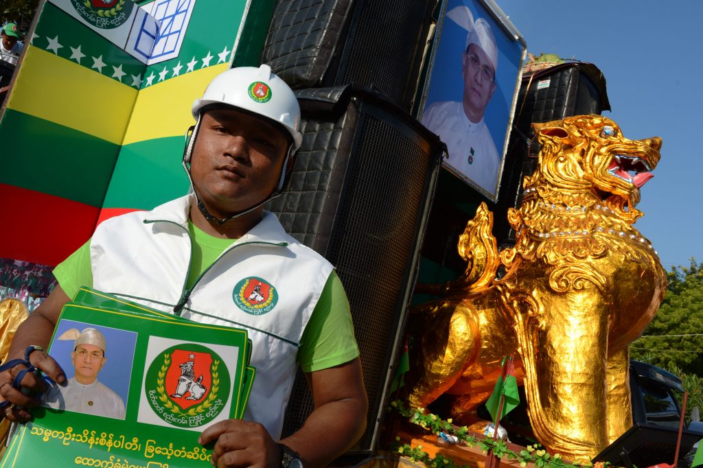 A Union Solidarity and Development Party supporter holds posters bearing the portrait of President U Thein Sein during a campaign rally in Nay Pyi Taw on October 28, 2015. (AFP)