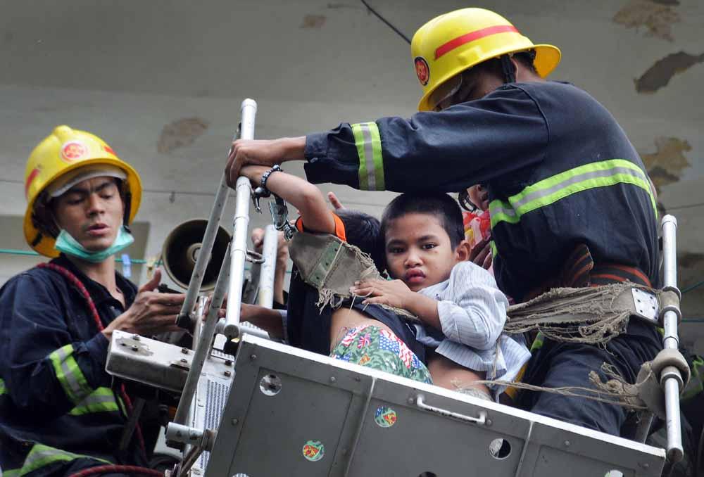 Firefighters attend a fire in a residential building in Shwe Bon Thar Street in downtown Yangon. (Steve Tickner / Frontier)