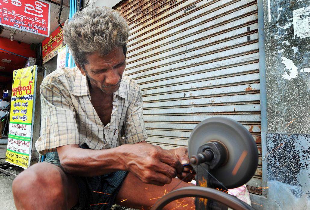 Streetside repairmen have been a constant presence in Yangon for decades. (Steve Tickner / Frontier)