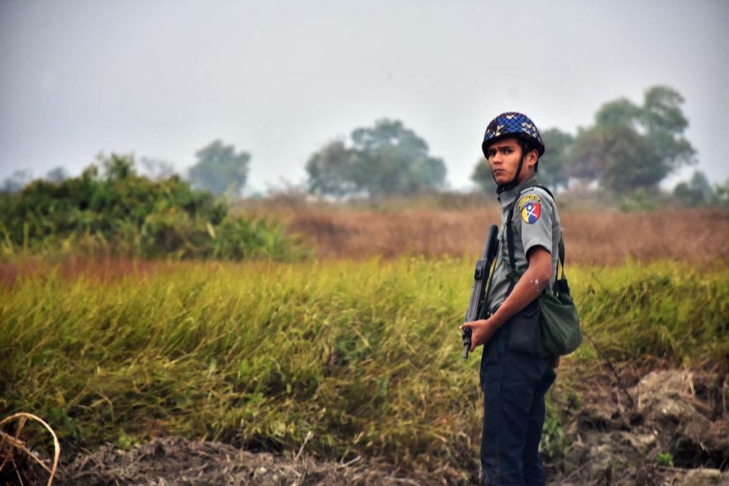 A police officer patrols the road between Maungdaw and Buthidaung in northern Rakhine State. (Steve Tickner | Frontier)