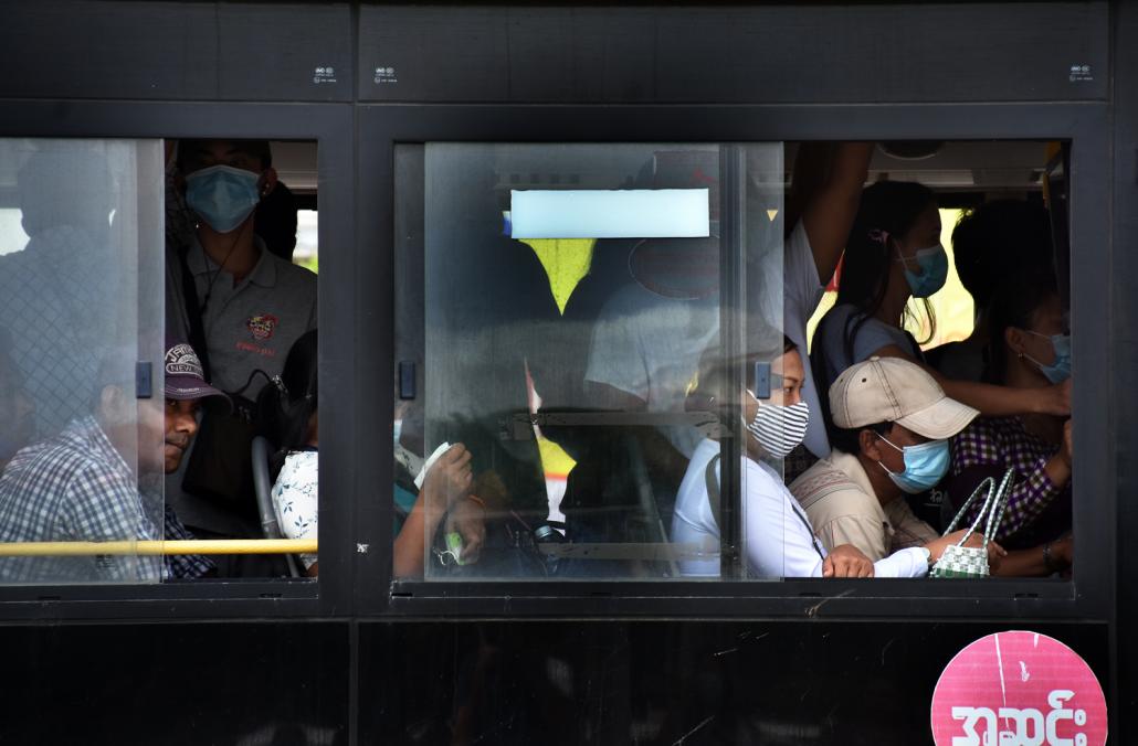 A crowded bus leaves from Maha Bandoola Garden in central Yangon on June 15. Fewer buses and fewer active routes have meant more crowded commutes, which increase the risk of infection. (Steve Tickner | Frontier)