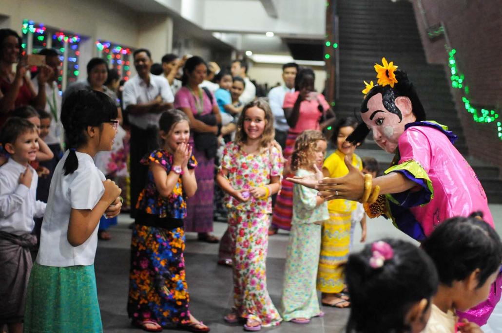 Dulwich students interact with a traditional entertainer during a Thadingyut celebration.