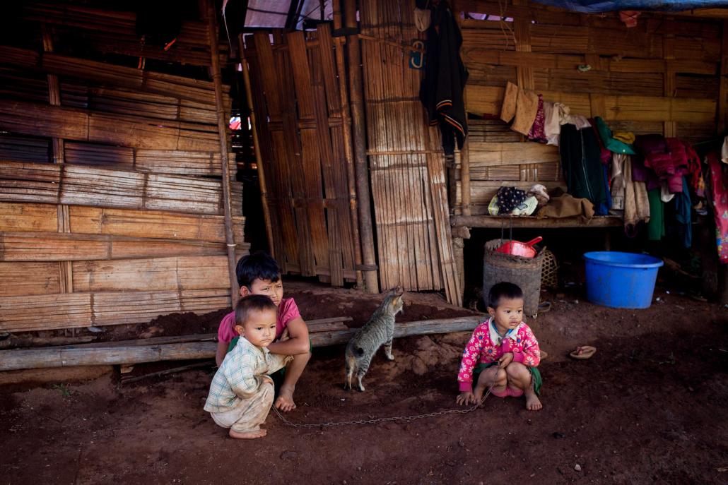 Children outside a home built for IDPs in Namtu. (Theint Mon Soe aka J | Frontier)