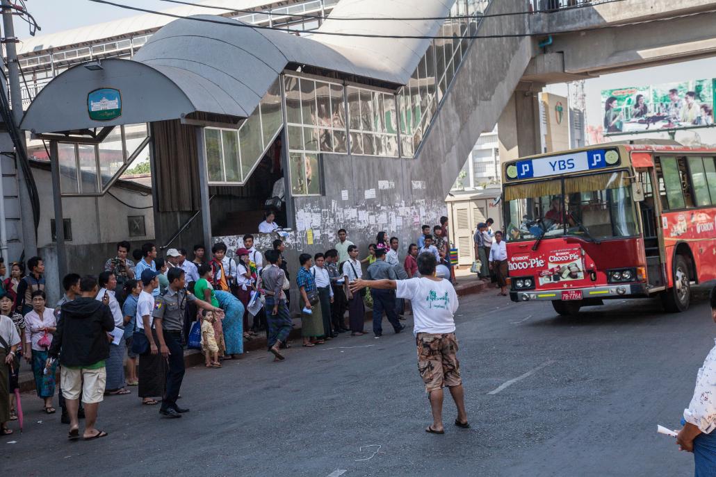 မော်တင်မှတ်တိုင်တွင် ဘတ်စ်ကား စောင့်ဆိုင်းနေကြသည့် ခရီးသည်များ။ ဓာတ်ပုံ-သိမ့်မွန်စိုး (J)