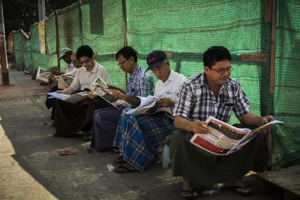 A group of men read newspapers in Yangon. (Maro Verli / Frontier)