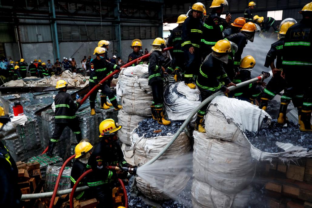 About 100 firefighters, including members of two volunteer brigades, used foam and water to drive back the blaze at a battery factory in Hmawbi Township on May 17. (Nyein Su Wai Kyaw Soe | Frontier)