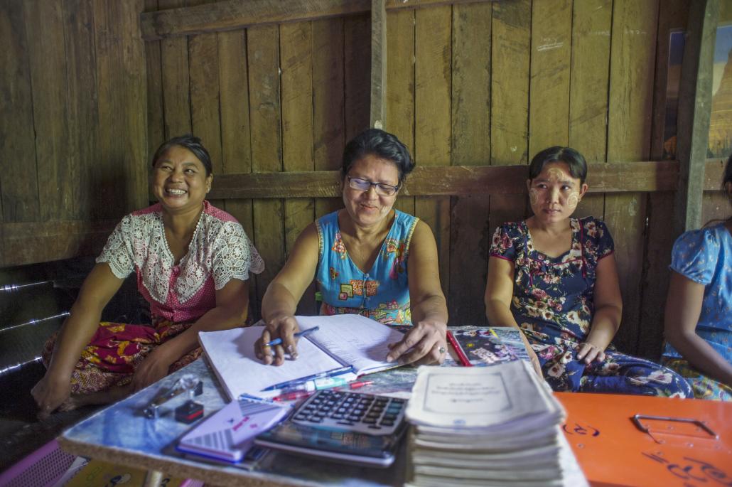 VSLA members from Kan Ni village in Minbya township laugh as they note down the savings contributions made by members during their fortnightly meeting. (Kaung Htet | Tat Lan)