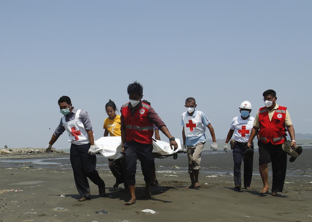 Red Cross members carry the body of a driver of a United Nations-marked vehicle that came under attack on April 21. The driver was killed in the incident, which also left a government health worker injured. (AFP)