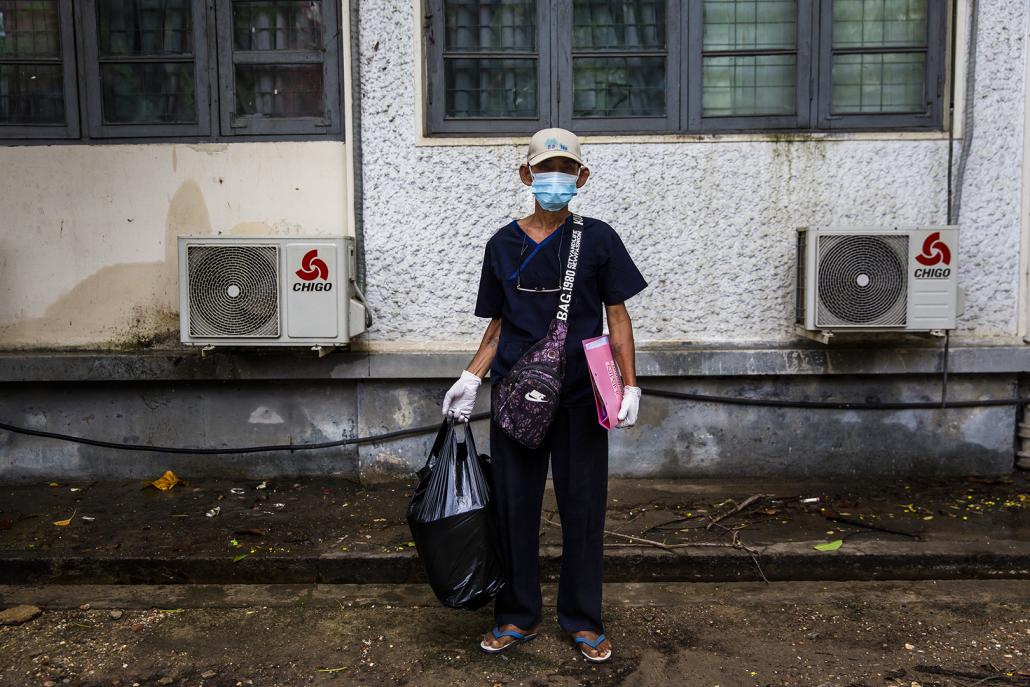 A medical worker arrives at the National Health Laboratory in Yangon on May 10 carrying a sample he has brought from Bago Region for testing. (Hkun Lat | Frontier)