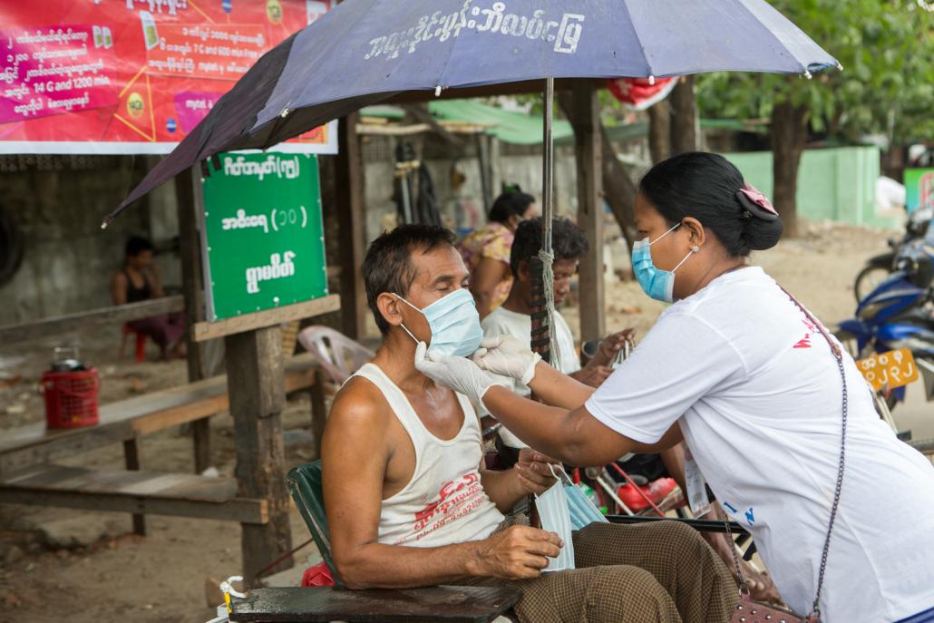 “We Love Insein” volunteers distribute facemasks to the public in Insein Township on May 17. (Thuya Zaw | Frontier)