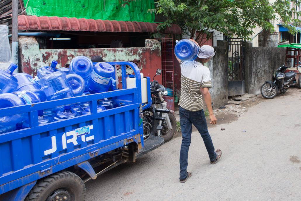 Small armies of workers deliver drinking water to homes and businesses each day, making them prime candidates for catching and spreading COVID-19. (Thuya Zaw | Frontier)