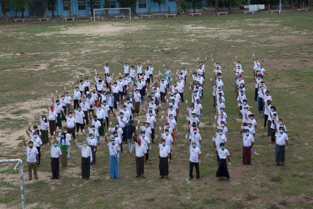 Volunteers for the “We Love Insein” charity pose for a group photo at the Government Technological Institute quarantine centre in Insein Township. (Thuya Zaw | Frontier)