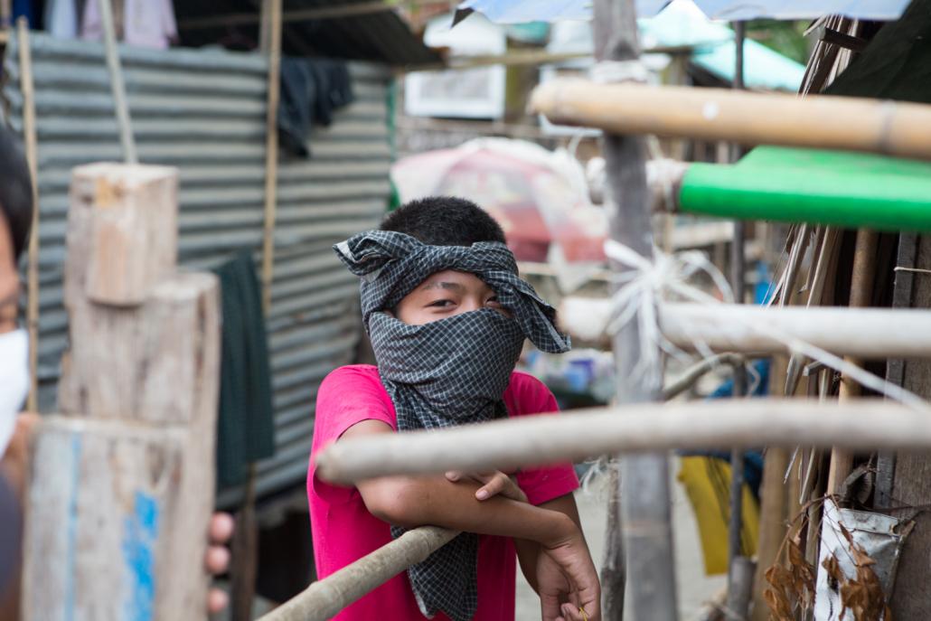 A boy uses a longyi as a facemask in Insein Township’s West Ywar Ma ward. (Thuya Zaw | Frontier)