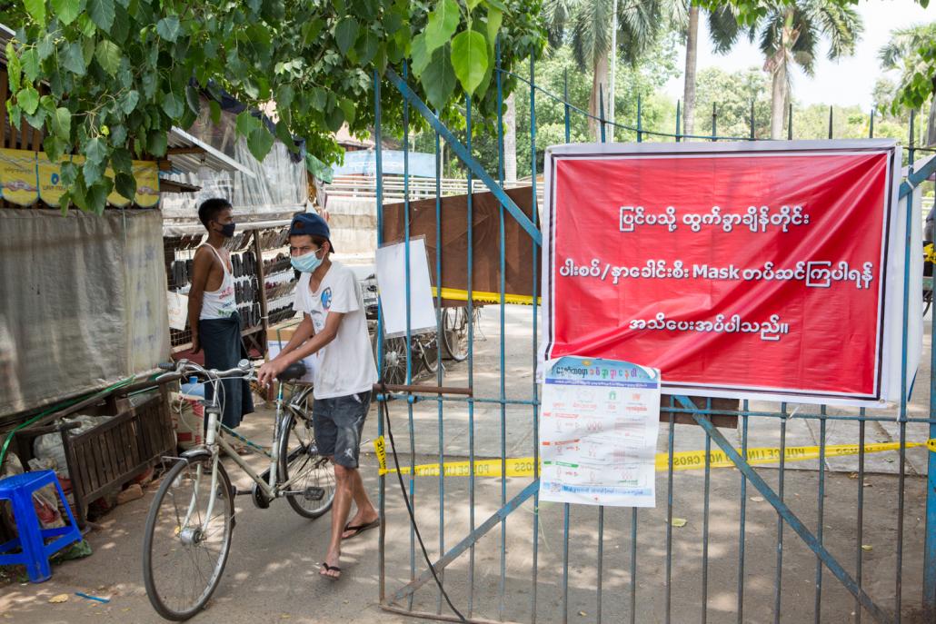 Residents of some wards in Insein Township have set up roadblocks and signboards warning people to wash their hands and wear facemasks. (Thuya Zaw | Frontier)