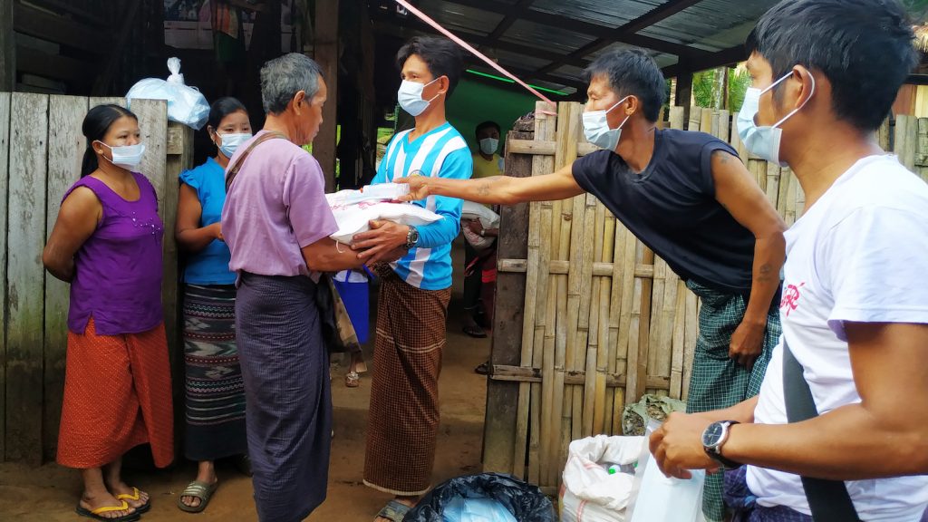 Members of the Mon Area Community Development Organization distribute bags of rice and health and hygiene items in Gani IDP site in eastern Ye township, Mon State, in early May. (Supplied | HURFOM)