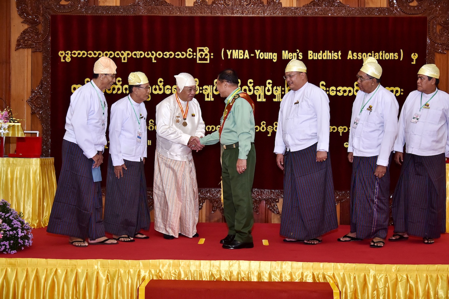 YMBA chair U Ye Htun shakes Senior General Min Aung Hlaing's hand after presenting him with an award and making him the group's patron for life in October 2019. (Supplied | CINDCS)