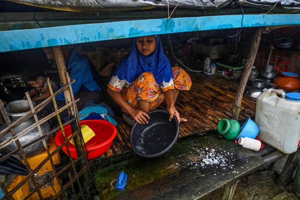 A Muslim woman cooks in her tent in the Kyauktalone camp in Kyaukphyu, Rakhine State, where Muslim residents have been forced to live for seven years after the inter-communal unrest tore apart the town. (AFP)