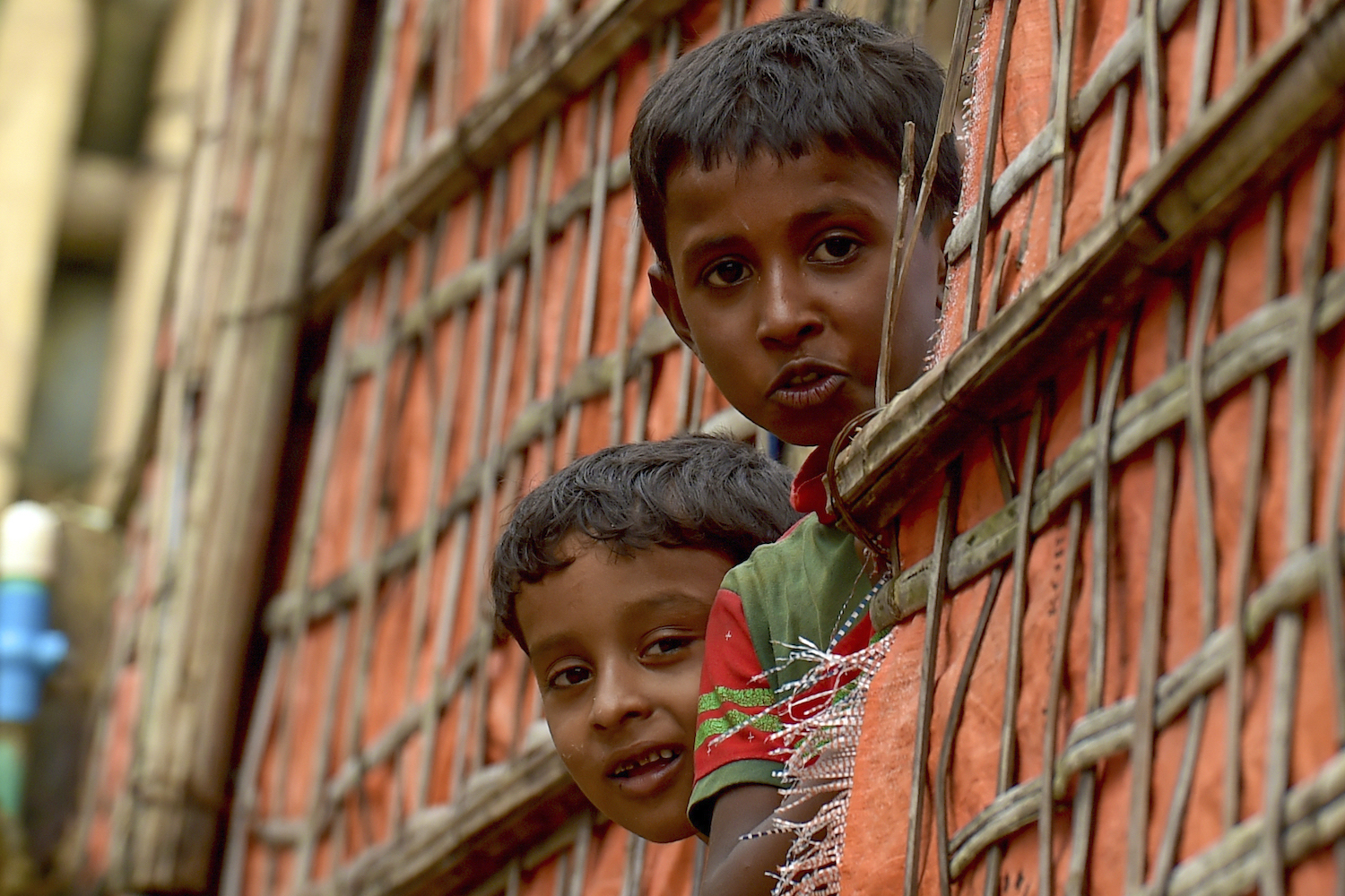 Rohingya refugee children look out from their shanty in Chakmarkul refugee camp in Teknaf on August 26, 2020. (AFP)