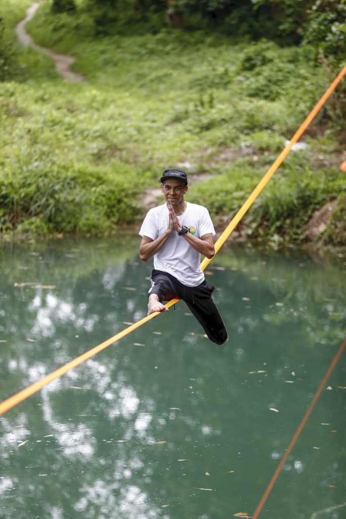 Ko Ye Win Tun balances on a slackline above a pond – what practitioners call "waterlining." (Nyein Su Wai Kyaw Soe | Frontier)