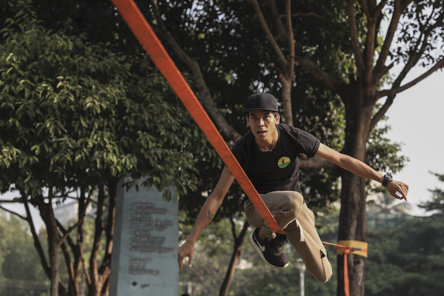 Ko Ye Win Tun, a slackline enthusiast and founder of the Myanmar Slackline Community Facebook page, practices the sport at the Duwun Orchard farm in Hmawbi Township. (Nyein Su Wai Kyaw Soe | Frontier)